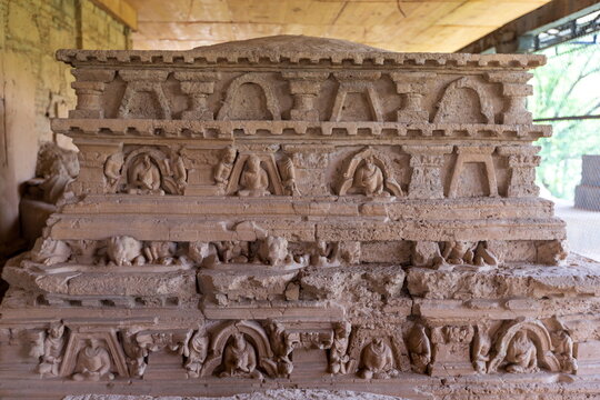 View of ancient stone carvings adorn a weathered structure, their intricate patterns hinting at stories untold, standing silently under a protective shelter, Taxila, Khyber Pakhtunkhwa, Pakistan.