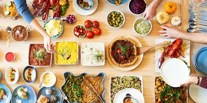 Top view of diverse people enjoy buffet with dishes like pasta, salads, and seafood. People enjoy eating buffet dishes, sharing a communal dining experience. Diverse people enjoy food at buffet table