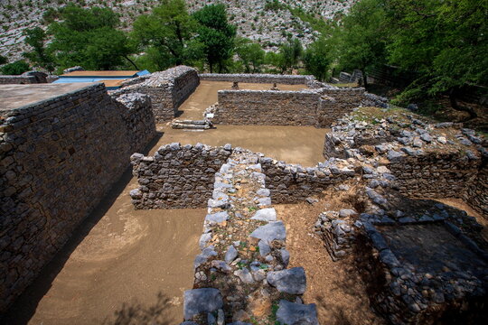 View of ancient stone walls and ruined structures bask in the warm light, remnants of a forgotten era, Off N-125, Taxila, Punjab, Pakistan.