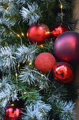 Winter holiday wall hanging decorations  with artificial pine tree branches, red shadows balls and garland of small yellow lights. Seasonal ,winter holiday, christmas  decorations. 