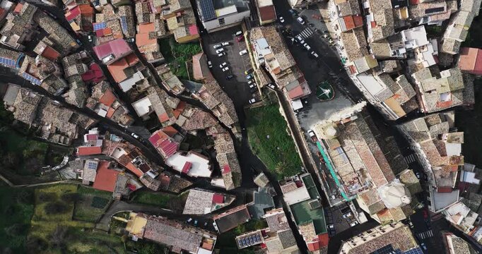 Aerial view of rooftops and narrow streets, showing contrasting colors of buildings in a densely populated area, Agira, Sicilia, Italy.