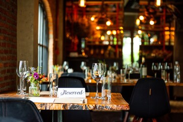Cozy restaurant with reserved sign on table, elegant decor, and warm lighting. Reservation sign on...