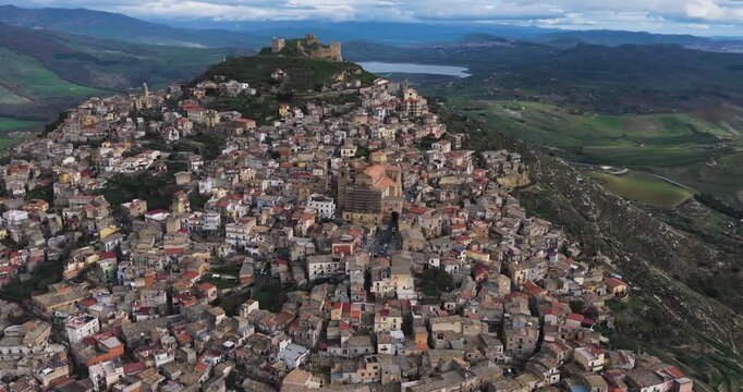 Aerial view of the tightly packed buildings in Agira, with the ancient castle ruins standing guard above the town, Sicilia, Italy.