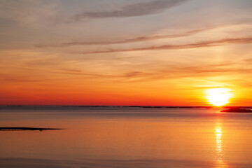 Obraz premium Norwegischer Sonnenuntergang über ruhiger Bucht und Insel.