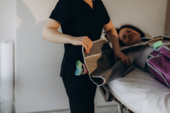 Woman receiving pressotherapy for lymphatic drainage in spa