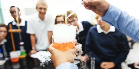 Students in a science class observe a chemistry experiment with a beaker. The science experiment captures their attention. Chemistry in action. Education, knowledge, and science.