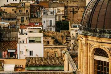 Panoramic View Over Ragusa From Cathedral Of San Giovanni Battista: Historic Sicilian City Rooftops, Church Domes, And Dense Stone Architecture Under Overcast Sky