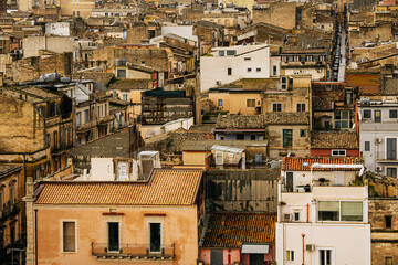 Panoramic View Over Ragusa From Cathedral Of San Giovanni Battista: Historic Sicilian City Rooftops, Church Domes, And Dense Stone Architecture Under Overcast Sky