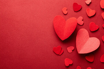 Obraz premium red hearts scattered on a red textured background