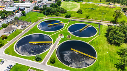 Complexo de tanques circulares utilizados no tratamento de esgoto por lodo ativado, destacando engenharia sanit&aacute;ria, saneamento b&aacute;sico e responsabilidade ambiental.