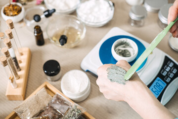 Hand of person applying cosmetic product to skin with spatula for sensory feedback. Texture...