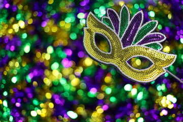 Mardi Gras background. Brightly colored mask glimmers against shimmering garlands and beads
