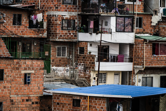 View of brick buildings layered upon each other create a textured landscape, with bright laundry lines adding pops of color, Medellin, Colombia.