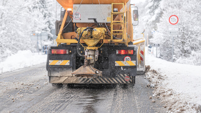 Snow plow sprinkling road salt for de-icing roads   from snow and ice.