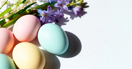 Colorful Easter eggs in pastel shades arranged with fresh flowers. The scene captures the essence of spring and festive celebrations.