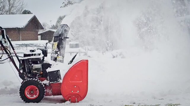 Man pushing a snow blower. Snow removal machine.
