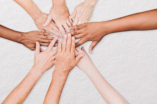 People stacking hands together in the park