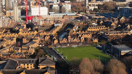 London urban landscape featuring residential buildings, modern construction, and an artificial turf football pitch
