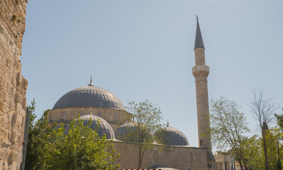Kesik Minare Mosque with its distinctive truncated minaret and domes under a clear blue sky in Antalya.