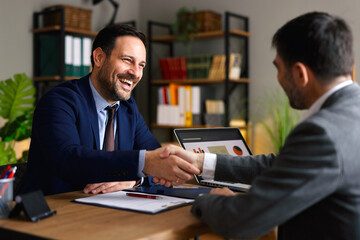 Two businessmen reaching an agreement and handshaking after a successful meeting