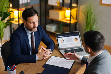 Businessmen analyzing data and agreement details during office negotiation