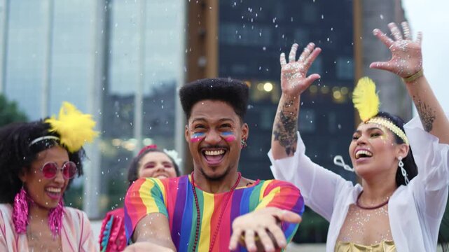 Energetic man dancing and throwing confetti during vibrant Brazilian Carnival celebration. Cheerful people enjoying the festive atmosphere in colorful costumes outdoors