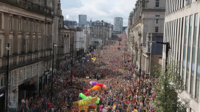 Massive crowd celebrates at a vibrant LGBTQ+ pride parade in a city street