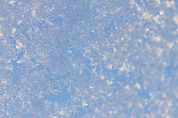 Ice flowers window, blue background and flowers made of ice forming on the window, beautiful blue background with ice crystals