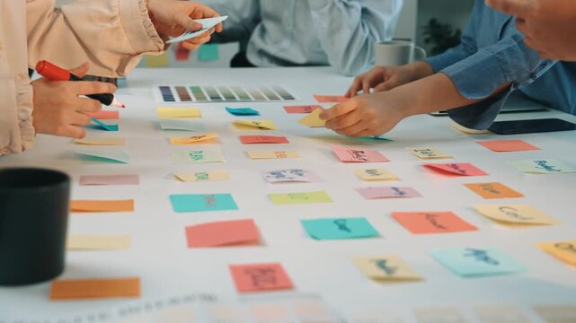 A vibrant office setting showcases a diverse team engaged in a collaborative brainstorming session with colorful sticky notes scattered across the table, fostering creativity. SACTR
