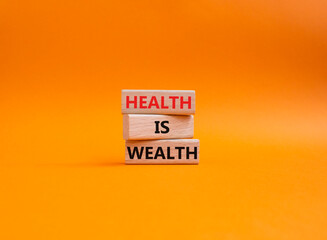 Health is Wealth symbol. Concept word Health is Wealth on wooden blocks. Beautiful orange background. Medicine and Health is Wealth concept. Copy space