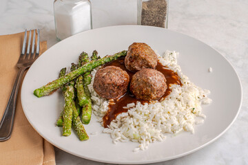  meatballs on rice and gravy with  asparagus