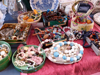 Antique flea market in Europe, Italy. Vintage items. Set of glass and stone beads. Jewellery and decorations on table, background for design.
