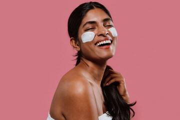  Young woman applying moisturizer on face