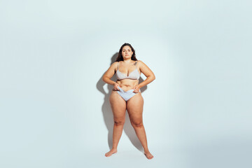 Plus size woman posing in studio in lingerie