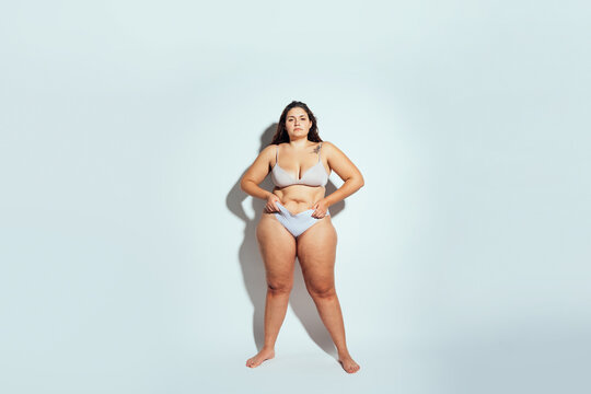 Plus size woman posing in studio in lingerie