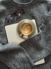 Cozy Gray Sweater laptop Coffee Glasses. Soft Knit Texture, Ceramic Latte With Foam Art Resting On Paper Journal, Folded Wool Blanket, Reading Glasses Nearby, Neutral Palette,