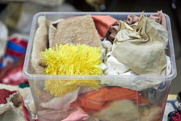 Creative workshop interior with plastic storage boxes filled with paints, fabrics, yarn, and craft materials. Colorful shelves and tools create an inspiring handmade art studio atmosphere