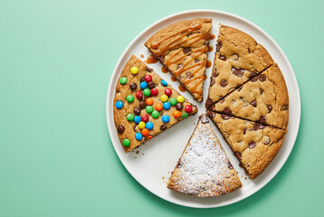 Assorted cookie slices on a white plate with green background  