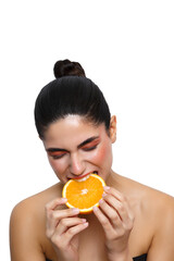 Young woman enjoying fresh biting orange studio shot