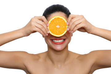 Woman smiling holding orange slice covering eyes