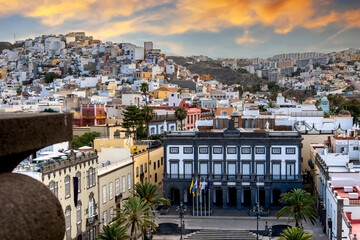 Las Palmas, Gran Canaria, Spain &ndash; Town hall Casas Consistoriales at Plaza Mayor de Santa Ana with palm trees and flags and buildings at sunset