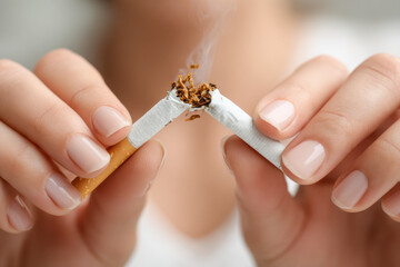 Person breaking a cigarette in half with both hands, symbolizing quitting smoking and promoting a healthy lifestyle change against tobacco use