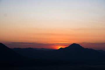 Obraz premium Breathtaking Sunset Over Mountain Range with Vibrant Colors and Sky