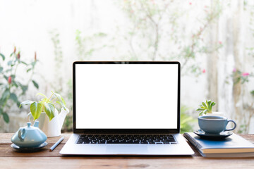 Blue tea pot and laptop with notebook arranged on wooden table