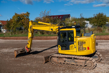Earthmoving Machinery Situated On Countryside Property Amid Homes And Flourishing Greenery