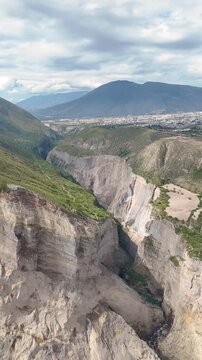 Vertical aerial drone footage flying over a large mountain ravine near the Pucar&aacute; de Rumicucho archaeological site close to Quito, Ecuador.