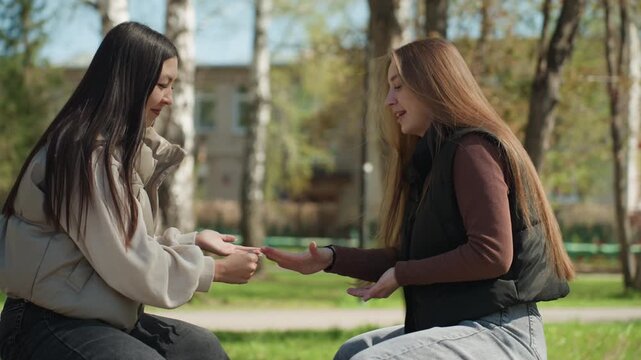 two buddies perform relaxed hand signals, friends engage in informal hand gesture contest outdoors, two friends participate in laidback hand signal competition outside during casual gathering