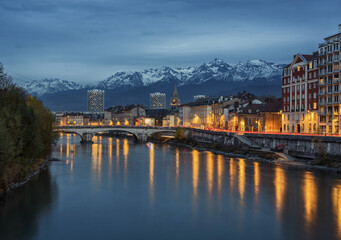 Obraz premium Grenoble France Snowy Mountains at Dusk with Riverside City Lights