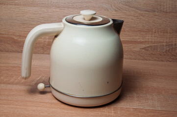 Vintage cream electric kettle with a retro design on a wooden background