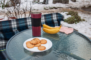 Outdoor picnic with cookies and bananas on a cold winter day